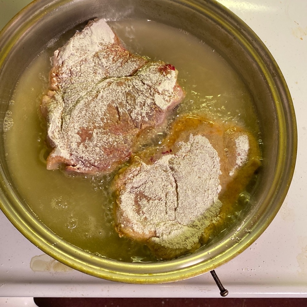 A nice southern cooked pork chop with a side of white rice and granulated sugar